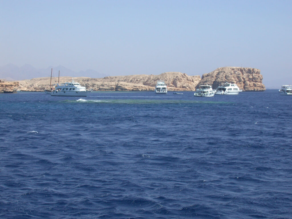 Dive boats moored in front of the pale cliffs of Ras Mohammed, above Shark and Yolanda Reef