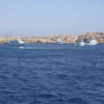 Dive boats moored in front of the pale cliffs of Ras Mohammed, above Shark and Yolanda Reef
