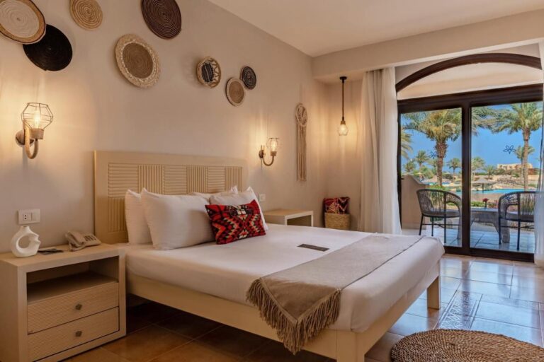 A double room decorated with woven baskets, opening onto a terrace and the pool