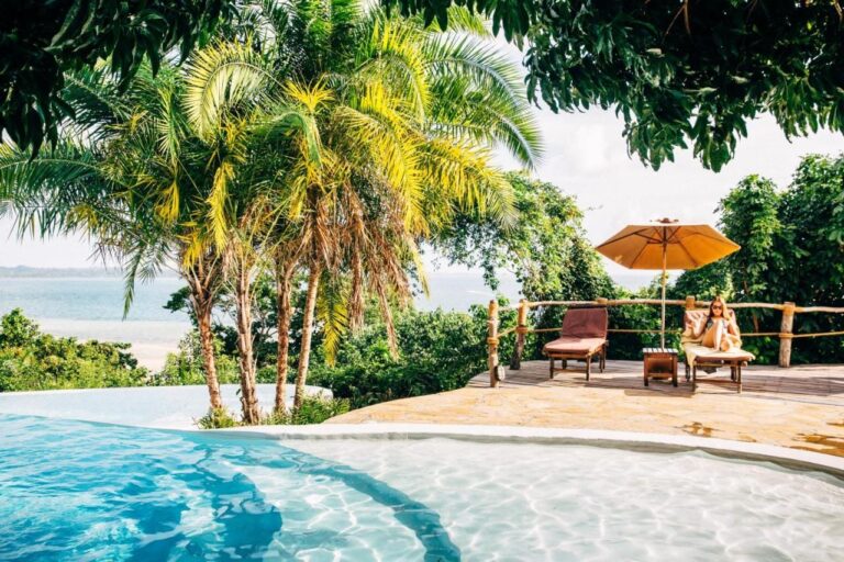 The infinity pool, its sun loungers and its orange parasol, facing the sea