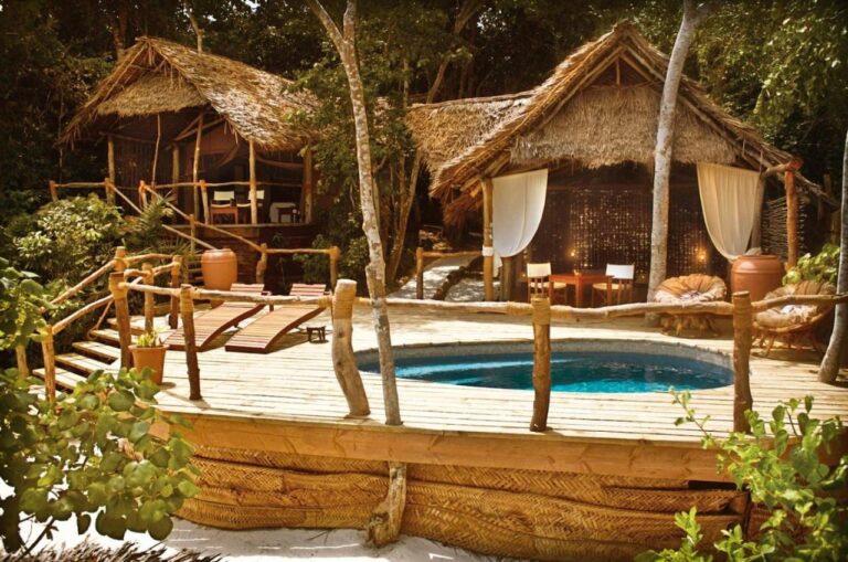 Two thatched bungalows and a wooden deck with a plunge pool and two sun loungers