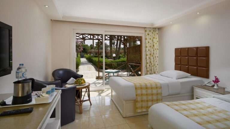 A twin room with two black armchairs, opening onto a terrace and the garden