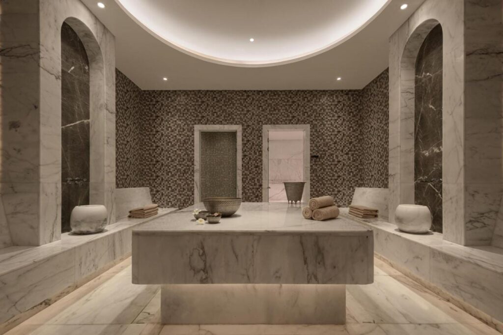 A marble-clad spa room at JAZ Elite Riviera, with a wide stone table in the center