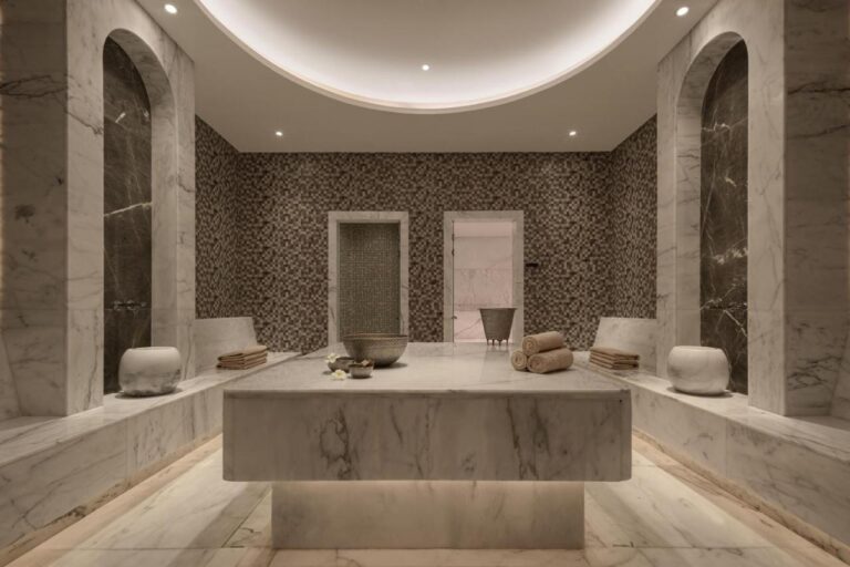 A marble-clad spa room at JAZ Elite Riviera, with a wide stone table in the center
