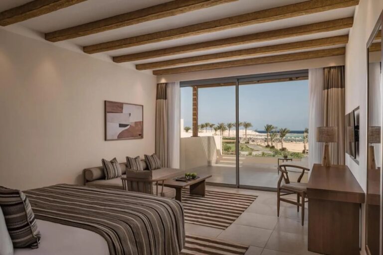 A room with a sitting area and a picture window facing the sea