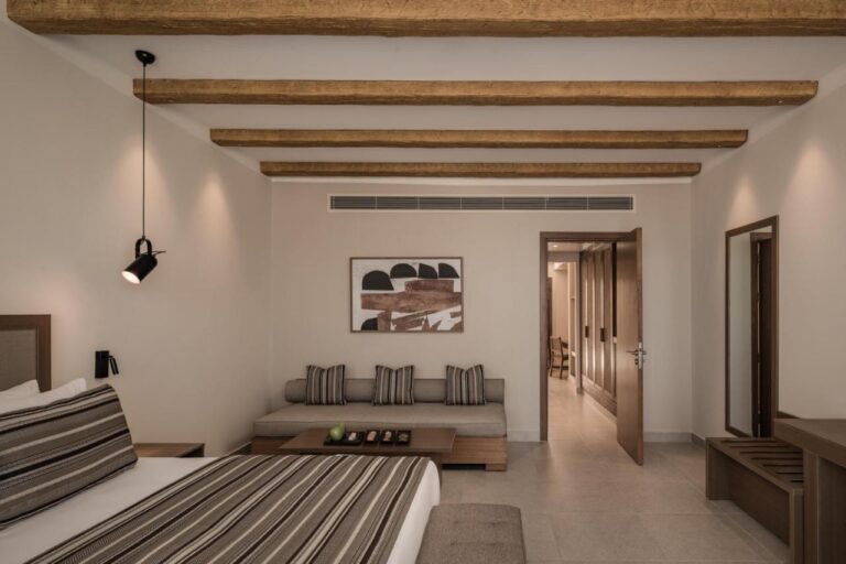 A suite with a sitting area at the foot of the bed