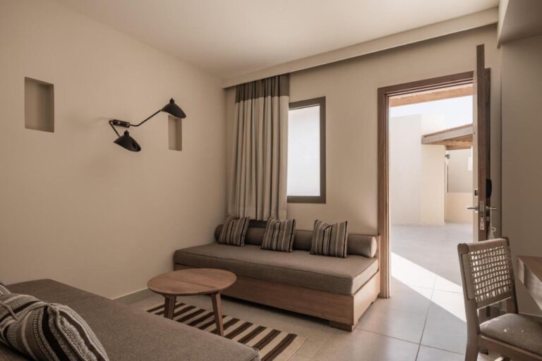 The sitting area of a room, with a bench seat and a door open to the outside