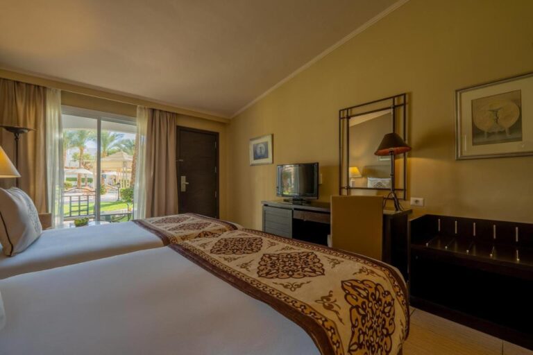 A twin room with a French window onto the garden and the palm trees