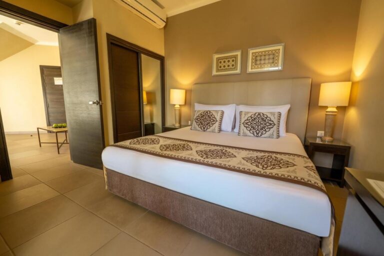 A double room with a mirrored wardrobe and a door open onto another room