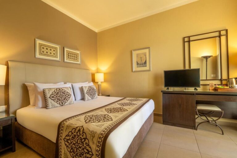 A double room with a desk, a TV and a large mirror