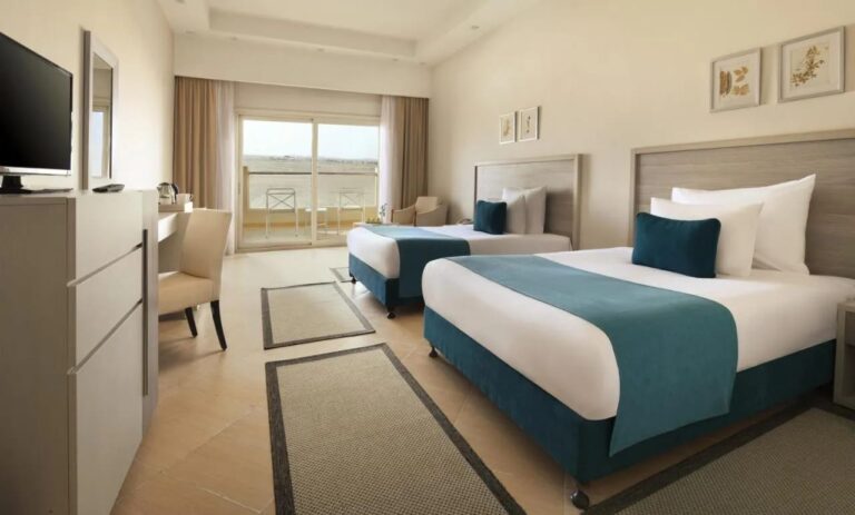 A twin room with a desk and a balcony