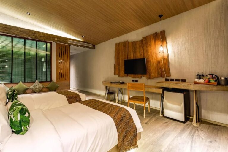 A twin room with a window seat, a desk and a tea tray