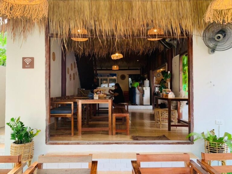 The restaurant dining room, with its wooden tables and rattan pendant lights