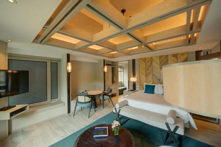 A double room with a table for two by the window and a TV