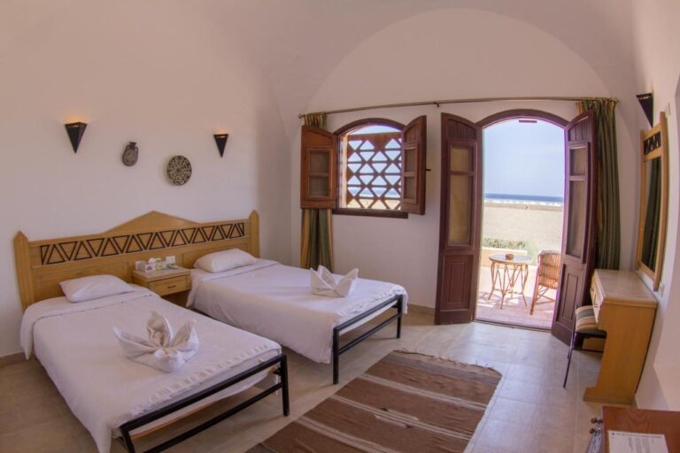 A twin room opening onto a terrace, facing the beach and the sea