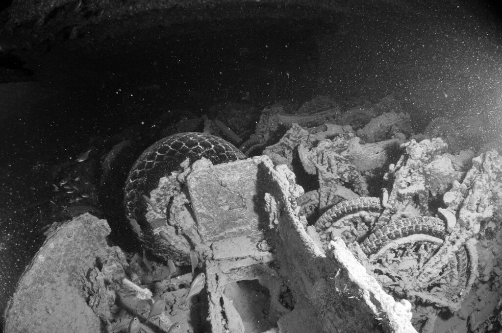 Motorcycles stacked in the hold of the Thistlegorm, black and white photo, tires and wheels still visible