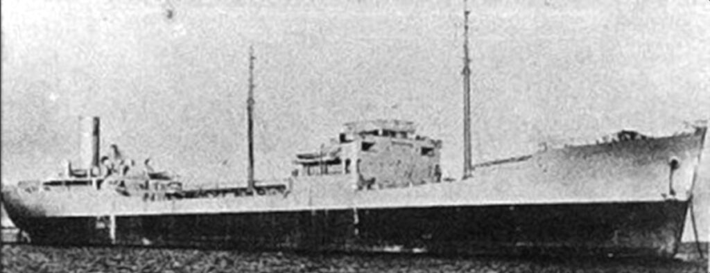 A grainy black-and-white archive photo of a tanker in profile, with its bridge amidships, two masts and its funnel aft.