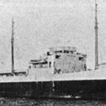 A grainy black-and-white archive photo of a tanker in profile, with its bridge amidships, two masts and its funnel aft.