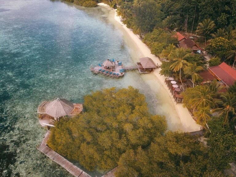 Aerial view of the white sand beach, the red-roofed buildings and the decks