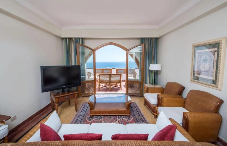A living room opening through an arched door onto a terrace facing the sea