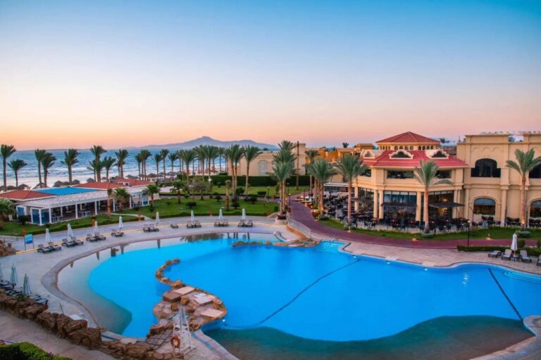 The large pool at Rixos Sharm El Sheikh at sunset, in front of the palm trees and the Sinai mountains