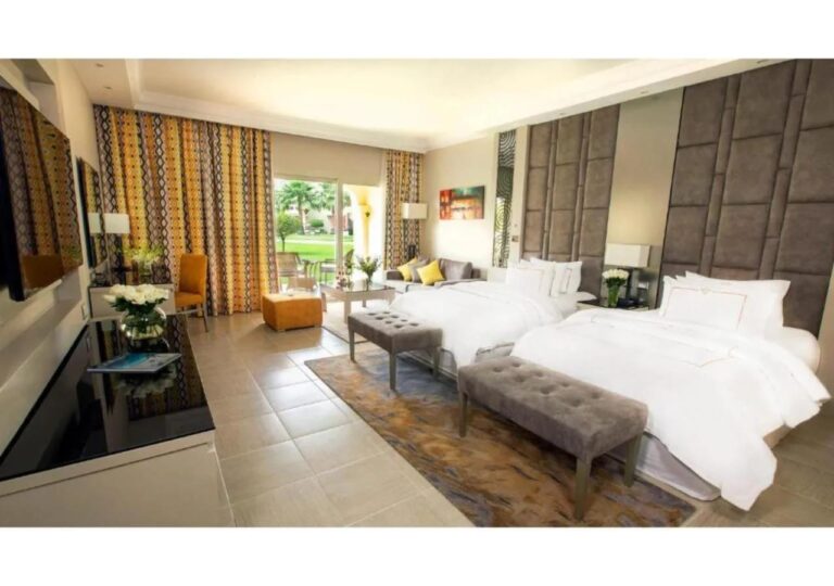 A twin room with a seating area, opening onto the garden