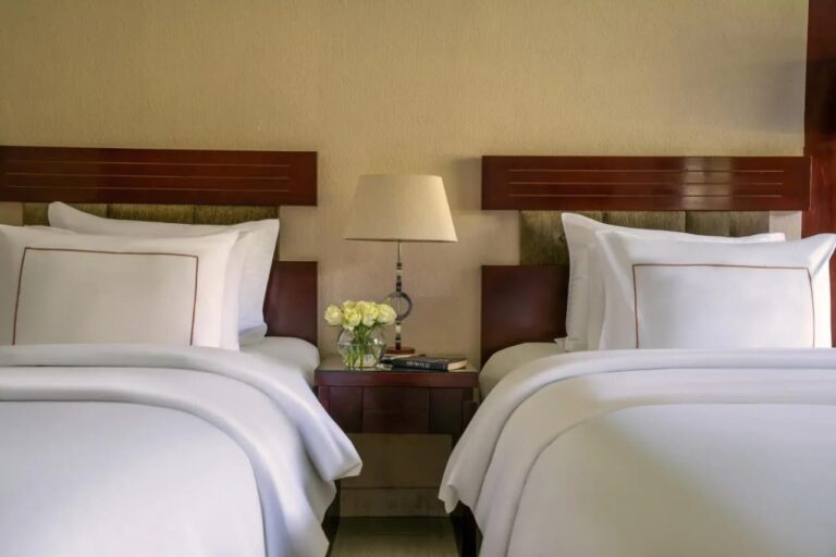 Two twin beds separated by a nightstand and a lamp