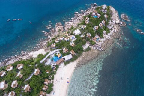 Aerial view of Sai Daeng Resort, with its bungalows on a rocky point, its pools and its sandy beach
