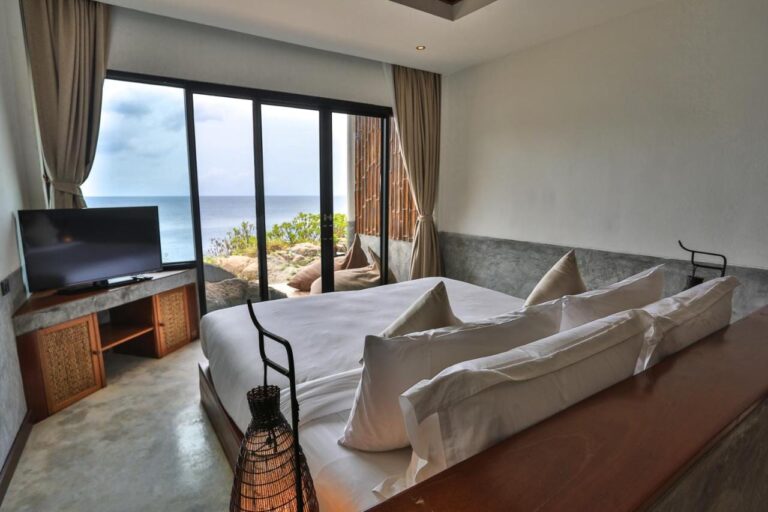 A room at Sai Daeng Resort with a picture window onto the sea and the rocks