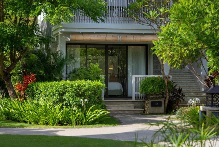 The entrance to a guest room building, surrounded by tropical plants