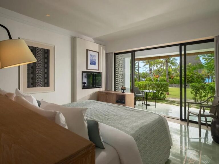 A room with a double bed opening onto the terrace and the garden