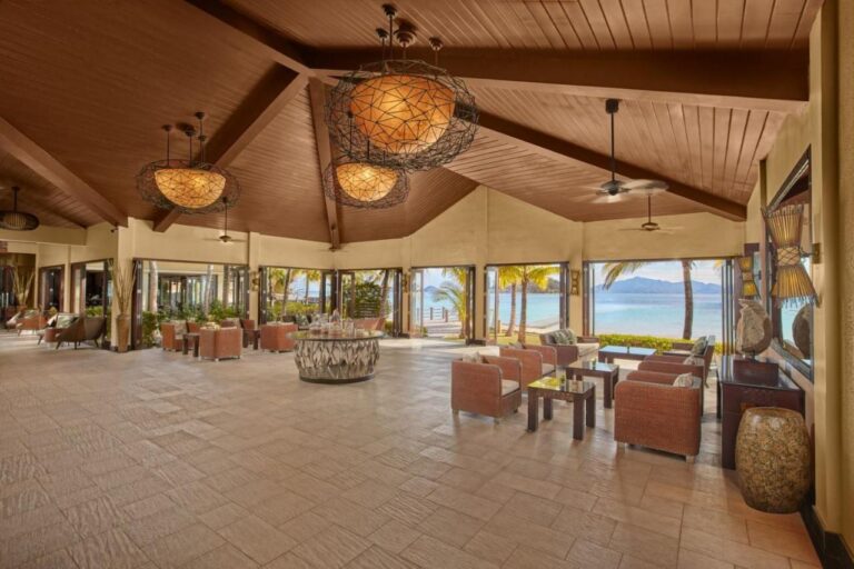 The lobby of Two Seasons Coron, open to the beach, with its woven armchairs and large pendant lights
